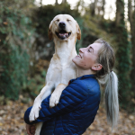 O femeie ținând un câine - Pets Care Veterinary Clinic Webflow Template